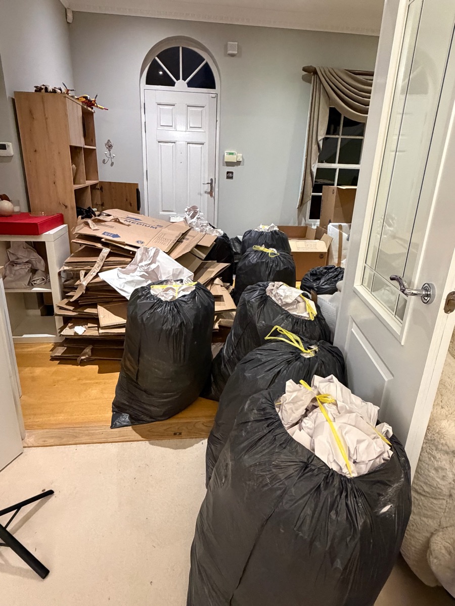 Flattened moving boxes and tied packing waste cleared into one room by Studio 14 during the Sevenoaks relocation