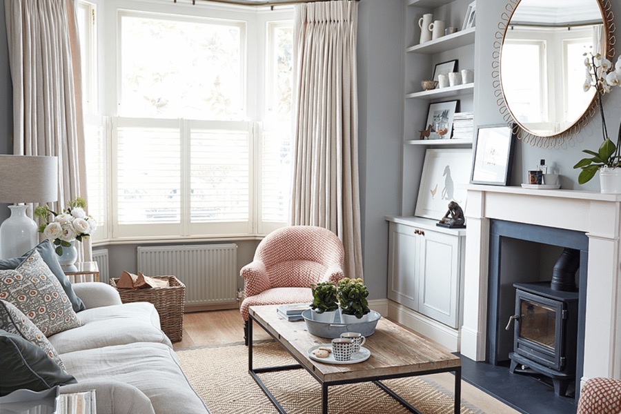 Living room in a London home organised and styled by Studio 14, with built-in shelving and a restored fireplace