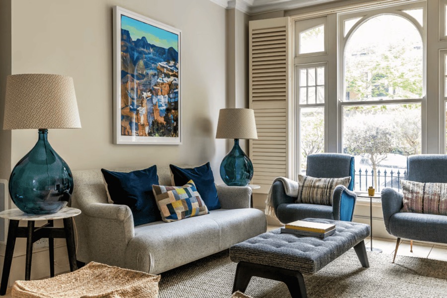 Reception room styled by Studio 14 with arched windows, blue glass lamps and a linen sofa
