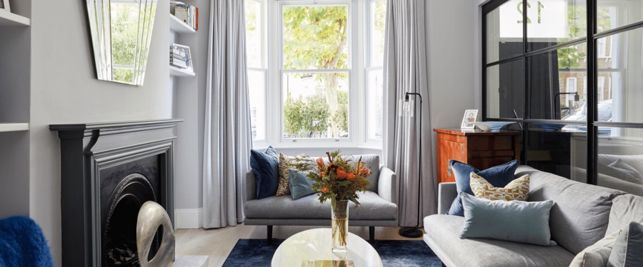 Living room organised by Studio 14 with a marble fireplace and symmetrical shelving