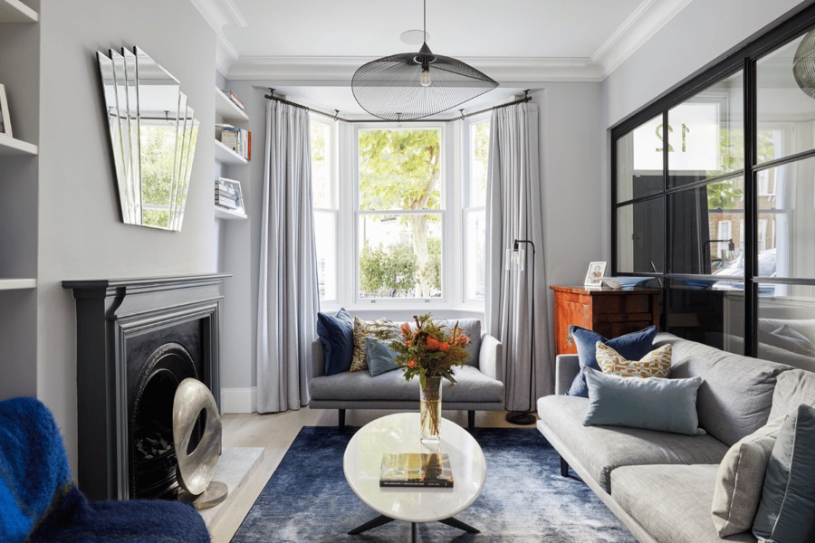 Reception room styled by Studio 14 with a period fireplace and contemporary furniture